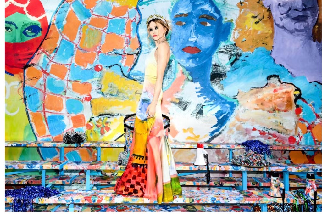 Woman in a long colorful gown in foreground and a coordinating mural in the background
